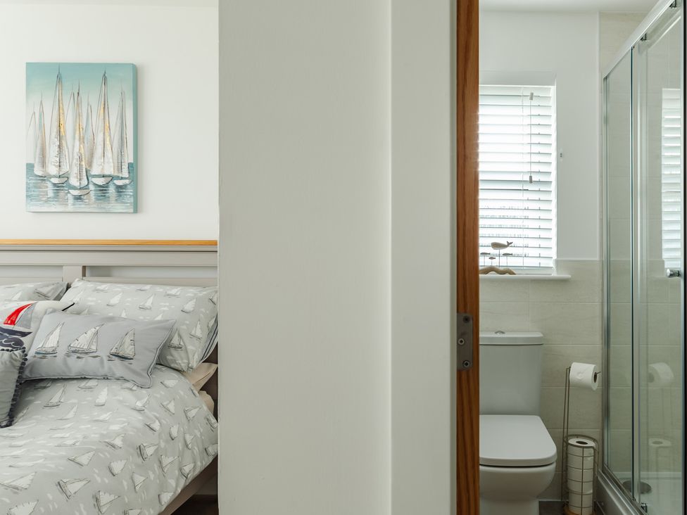 A bedroom with a bed and bathroom view at Wee Jules By The Sea