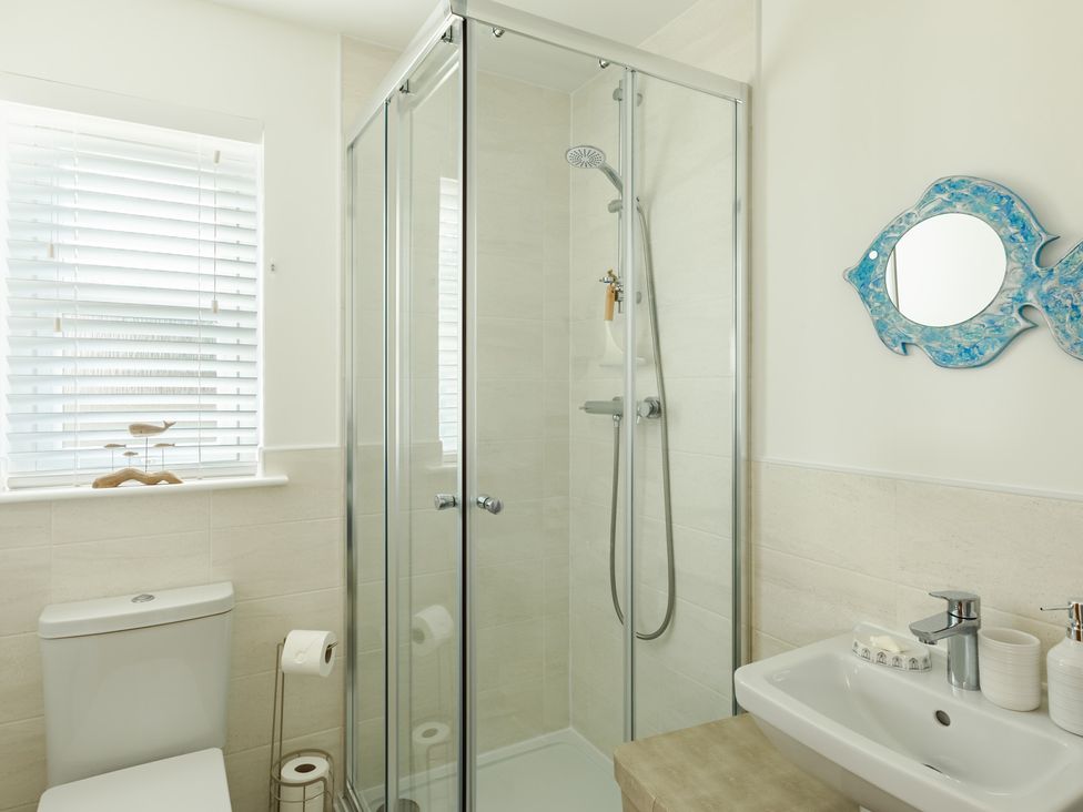 A bathroom with a shower, sink, and toilet at Wee Jules By The Sea