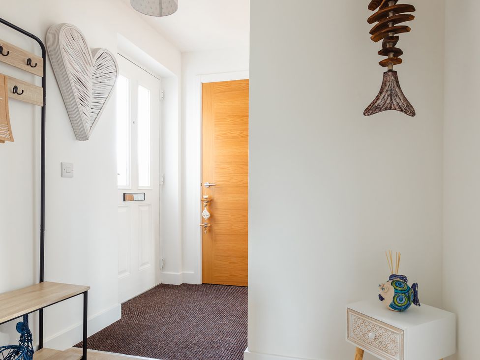 A hallway with a coat rack and decorative items at Wee Jules By The Sea