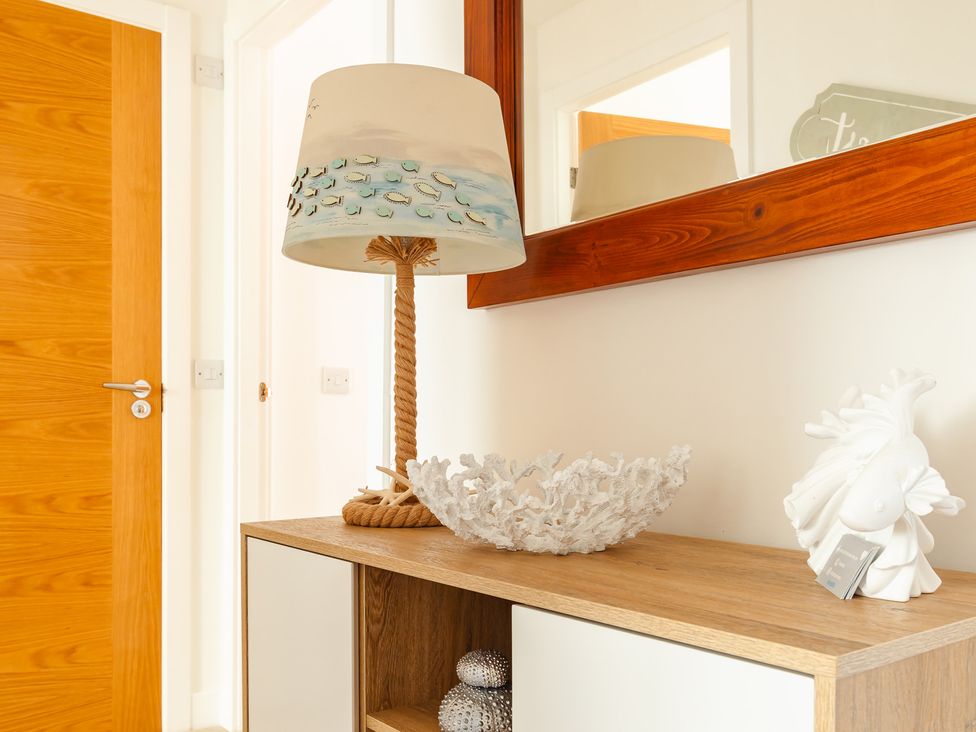 A hallway with a lamp and decorative items at Wee Jules By The Sea