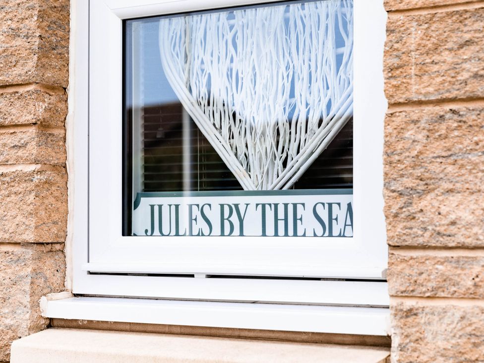 A window with a sign reading JULES BY THE SEA at the property
