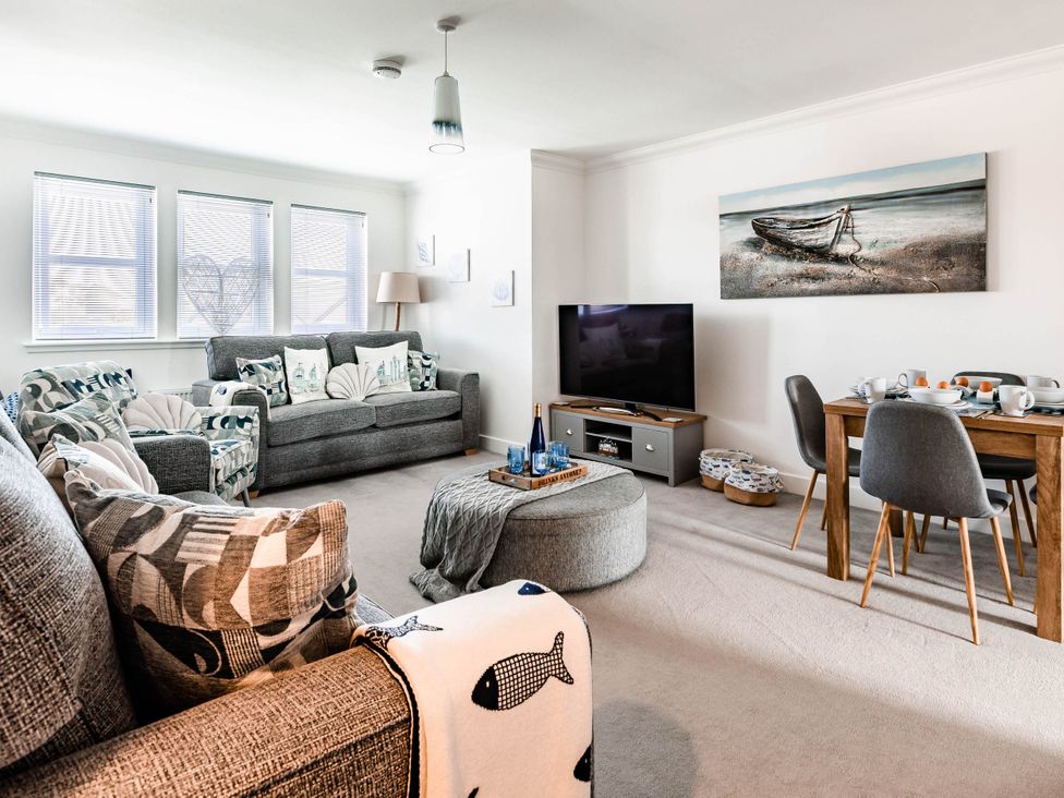 A living room with a sofa and dining table at The Old Barn in Manchester
