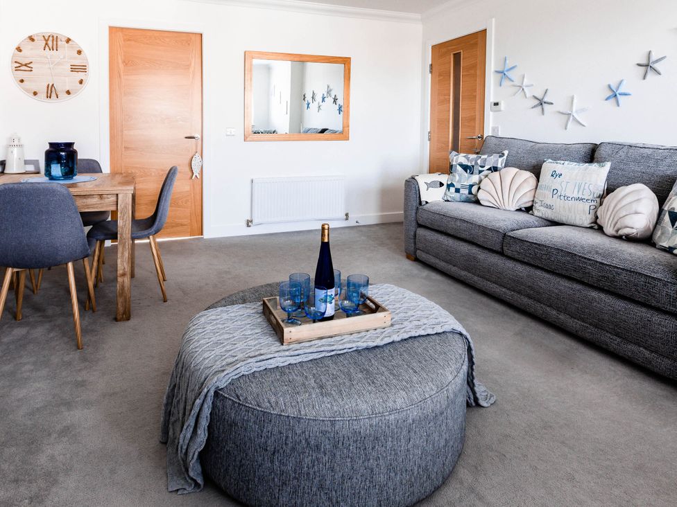 A living room with a sofa, dining table, and coffee table at The Old Barn in Manchester