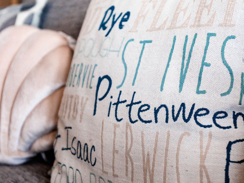 A decorative cushion with text patterns in a living room