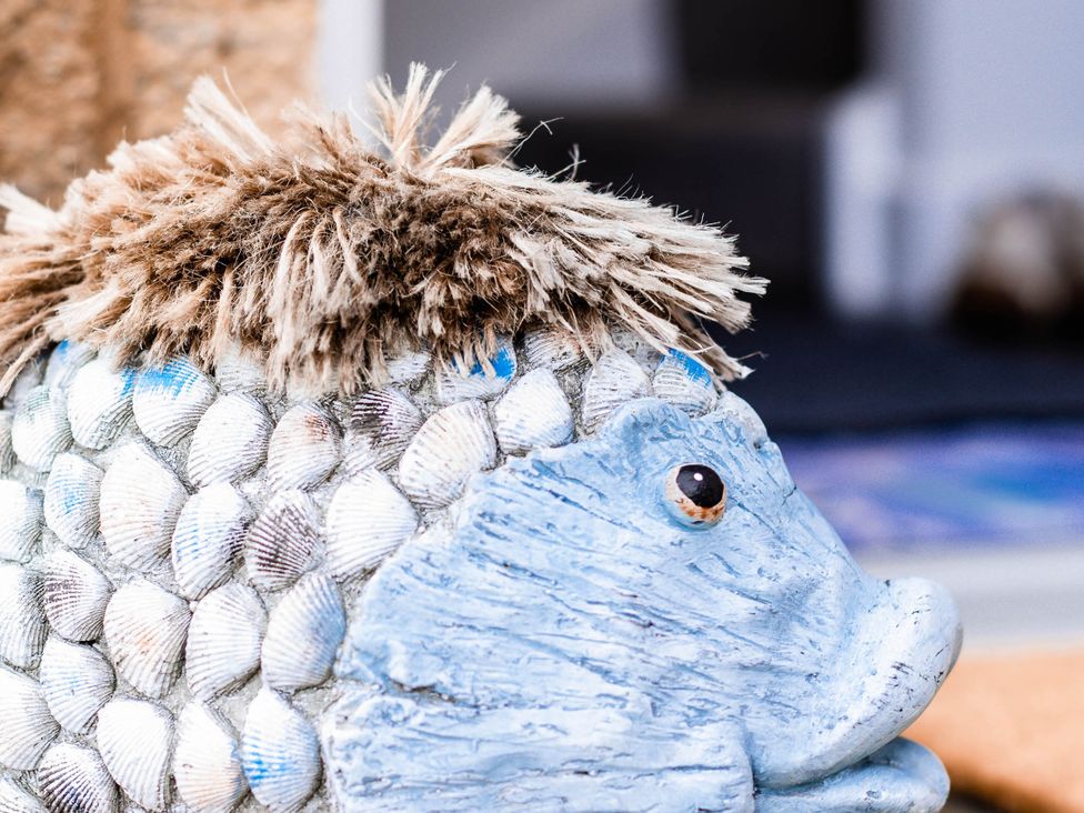 A decorative fish sculpture made of shells with faux fur at an unspecified location