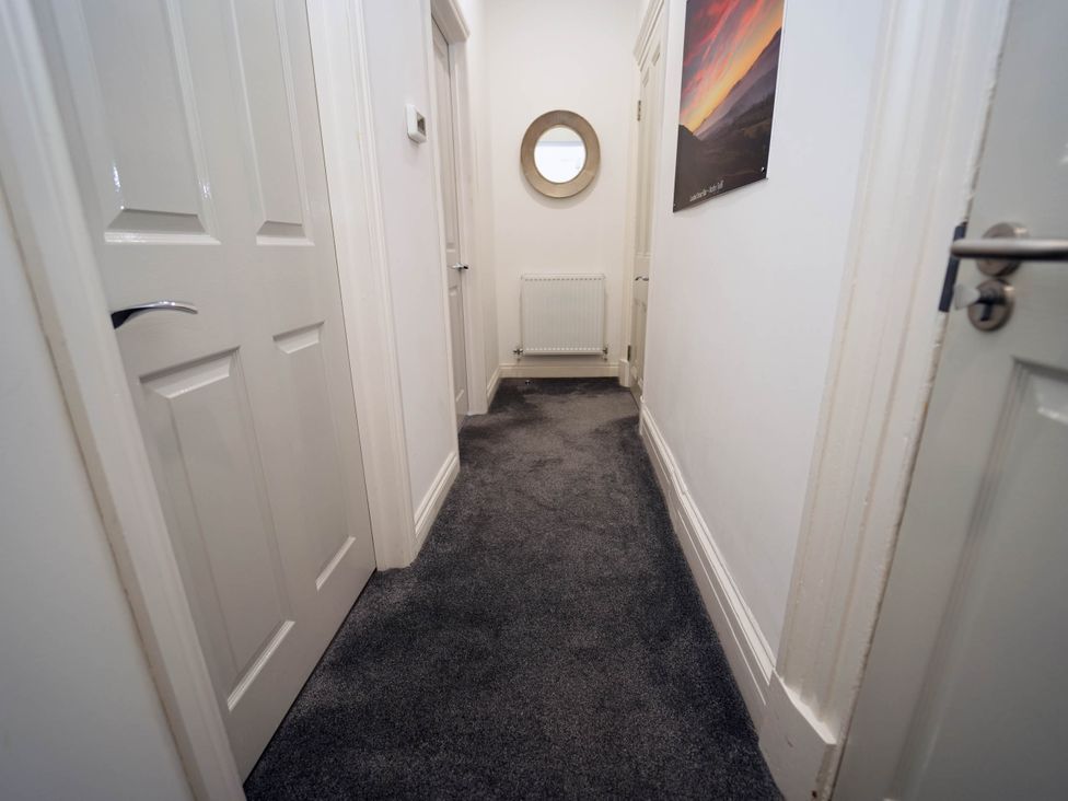 A hallway with doors and a mirror at 