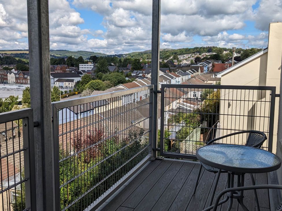 A balcony with a table and chair overlooking a residential area at the property location