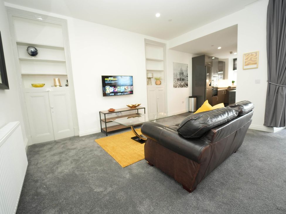 A living room with a sofa and television at The Old Barn in Manchester