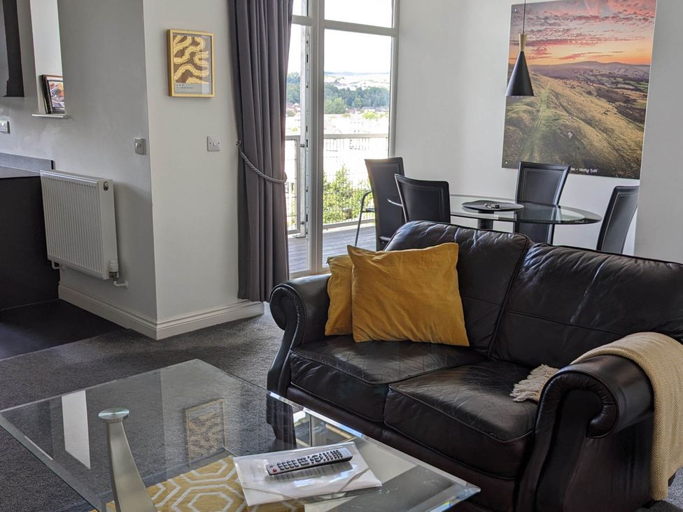 A living room with a sofa and dining area at the property in the location