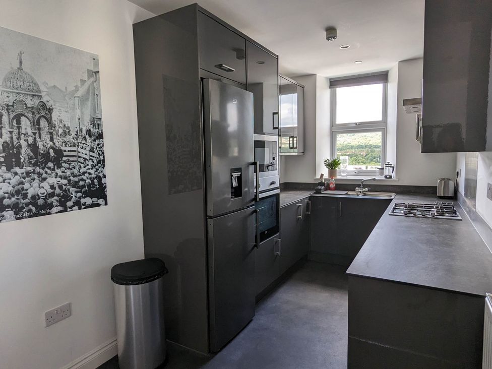 A kitchen with modern appliances and a window at The Old Barn in Manchester
