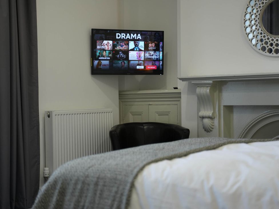 A bedroom with a television and radiator at The Old Barn in Manchester