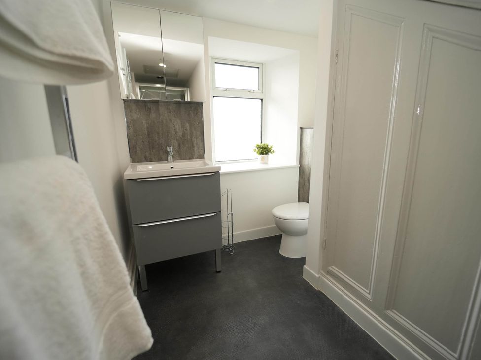 A bathroom with a sink, toilet, and mirror at 