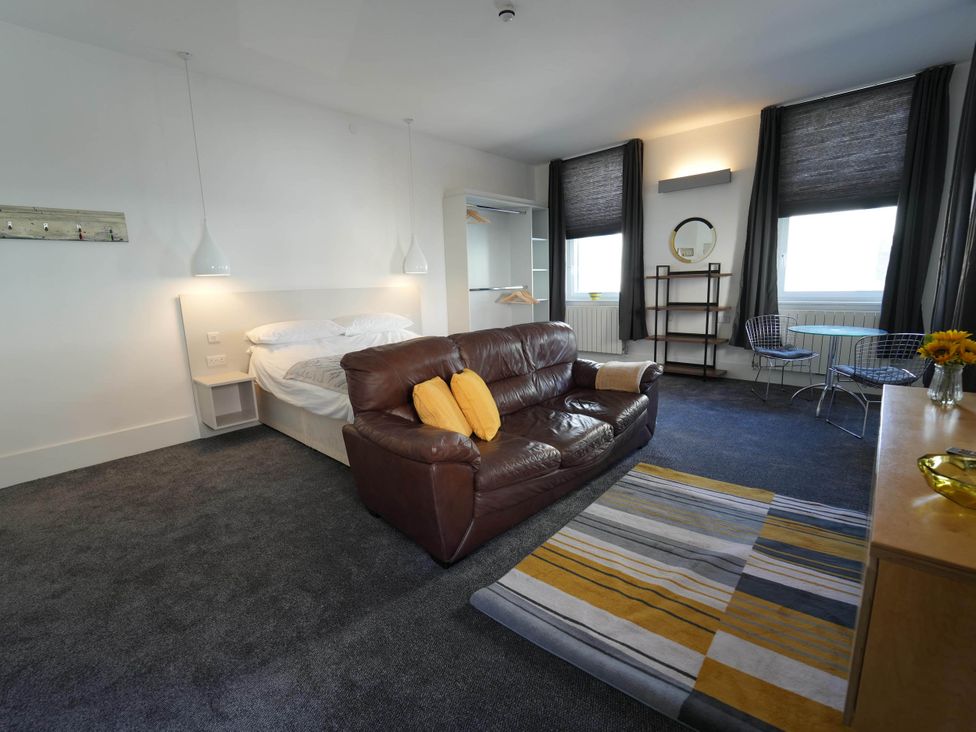 A bedroom with a couch and dining table at The Old Barn in Manchester