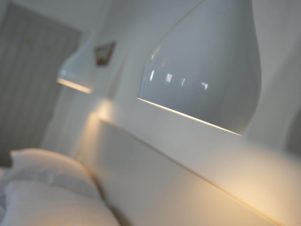 A bedroom with lamps and pillows at the property location