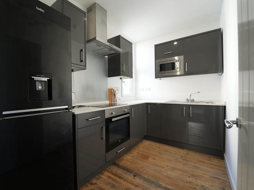 A kitchen with refrigerator, oven, sink and cabinets at the property 