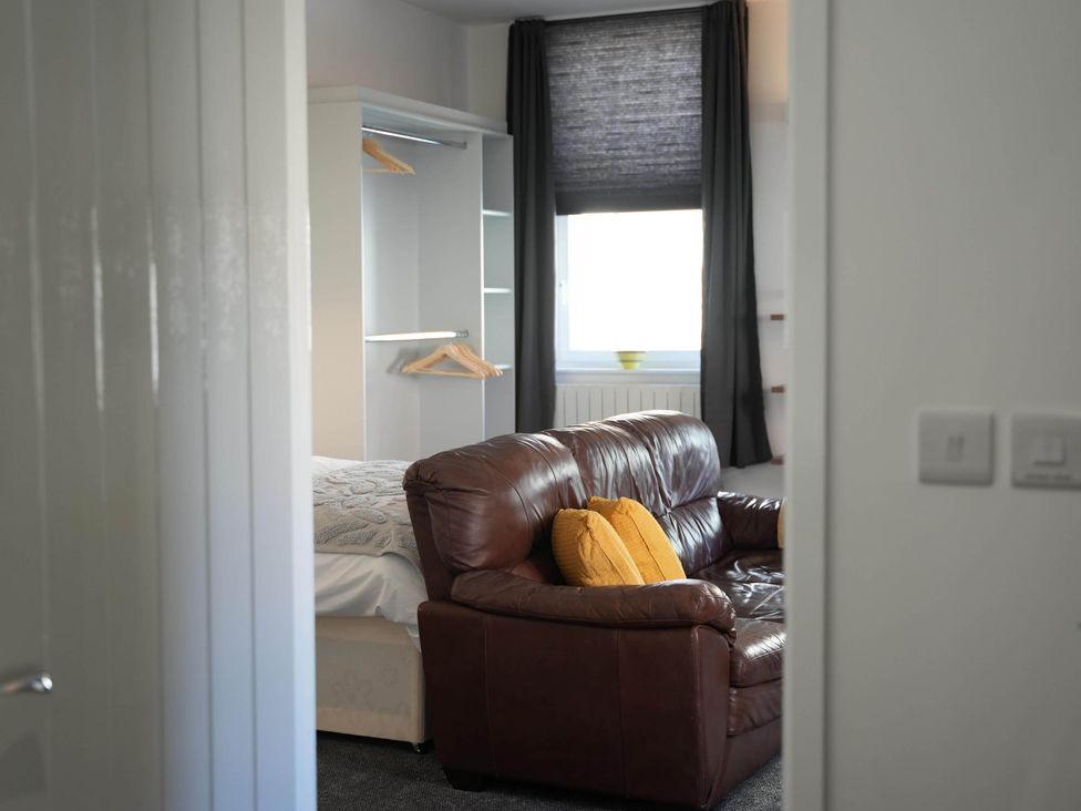 A bedroom featuring a sofa and wardrobe at the property location