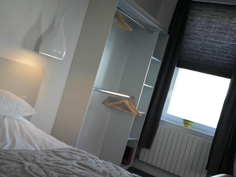 A bedroom with a bed and wardrobe at The Old Barn in Manchester