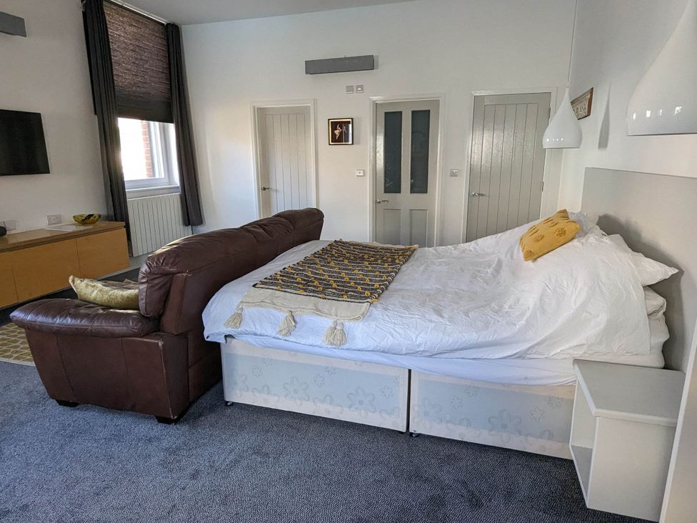 A bedroom with a sofa and bed at the property