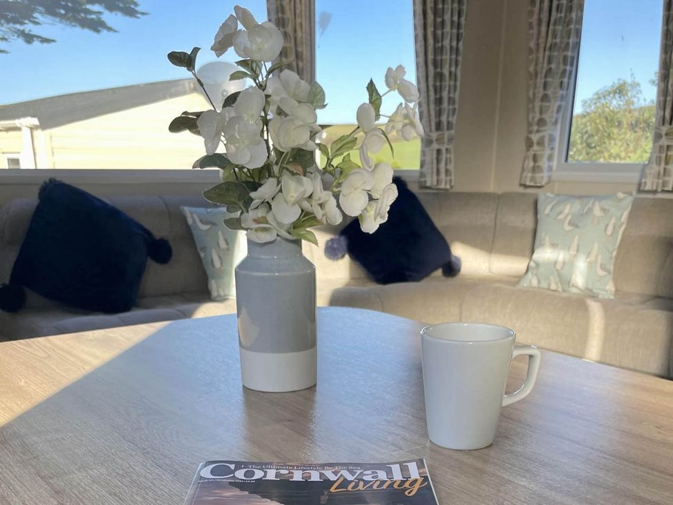 A living room with a coffee mug and magazine on the table at 