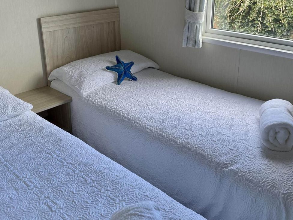 Two single beds with a starfish and rolled towels at a property in 