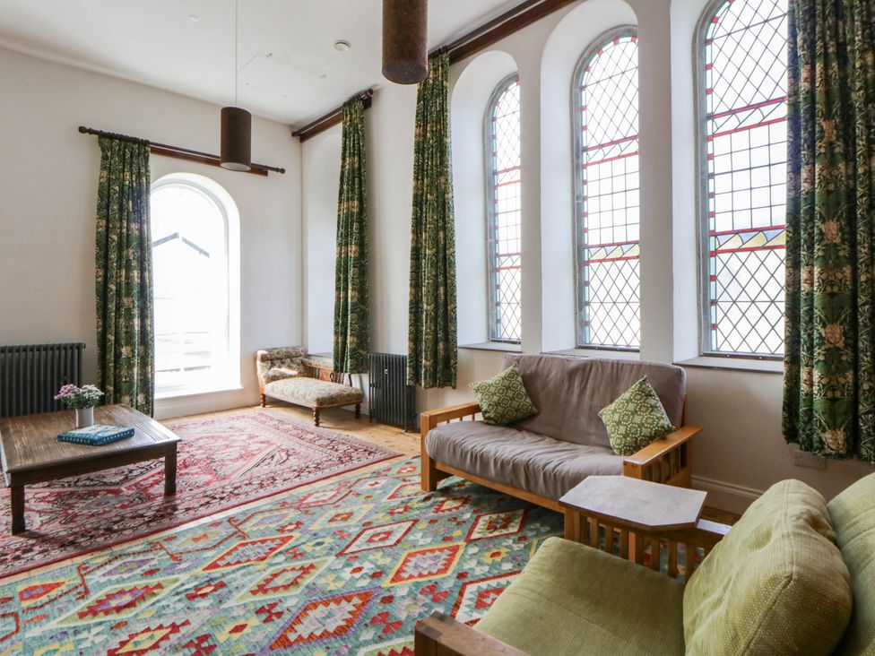 A living room with a table and sofas at Capel Llani Llanidloes