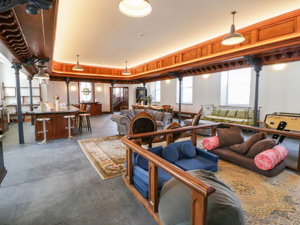 A living room with a kitchen island and seating arrangements at Capel Llani in Llanidloes