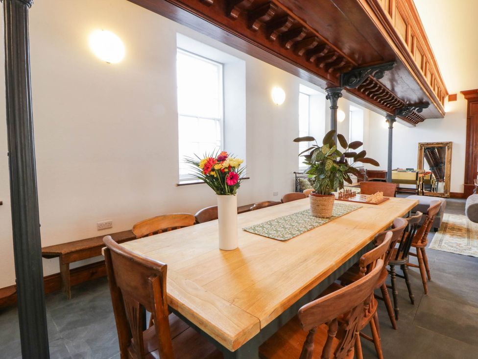 A dining room with a table and chairs at Capel Llani Llanidloes