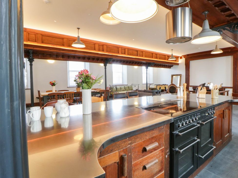 A kitchen with a dining area and a kitchen island at Capel Llani Llanidloes