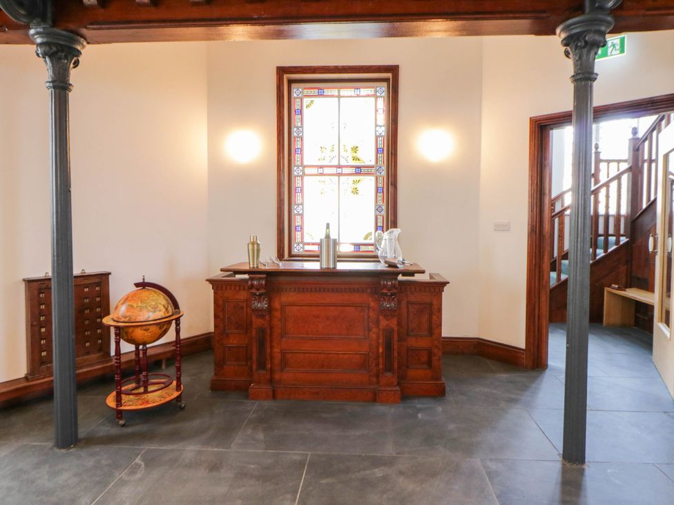 A hall with a wooden desk and globe at Capel Llani in Llanidloes
