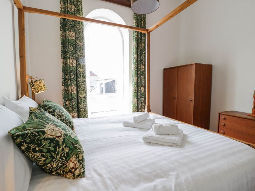 A bedroom with a bed and wardrobe at Capel Llani in Llanidloes