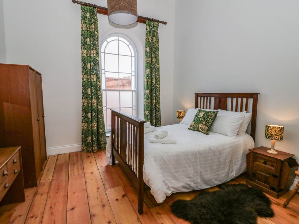 A bedroom with a bed and wardrobe at Capel Llani in Llanidloes