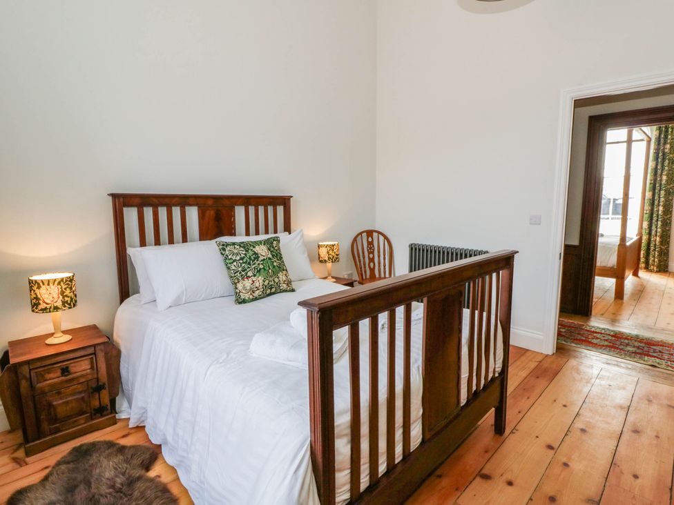 A bedroom with a bed and bedside table at Capel Llani in Llanidloes