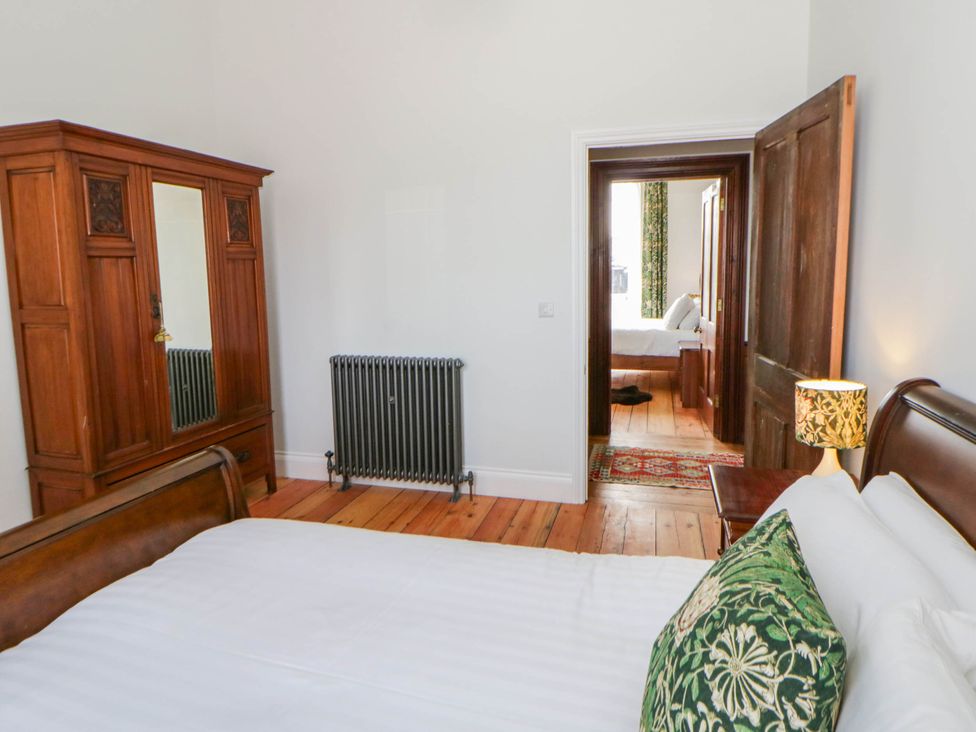 A bedroom with a bed and wardrobe at Capel Llani Llanidloes
