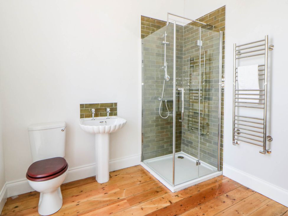 A bathroom with a shower, sink, and toilet at Capel Llani Llanidloes