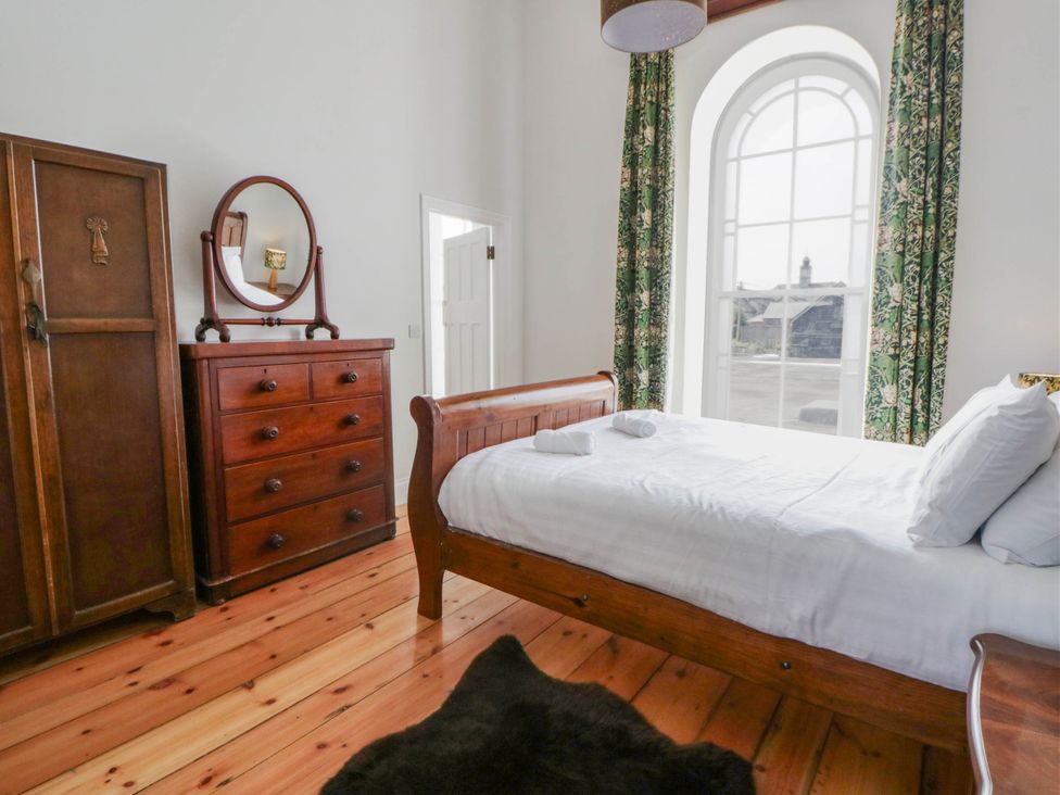 A bedroom with a bed and wardrobe at Capel Llani in Llanidloes