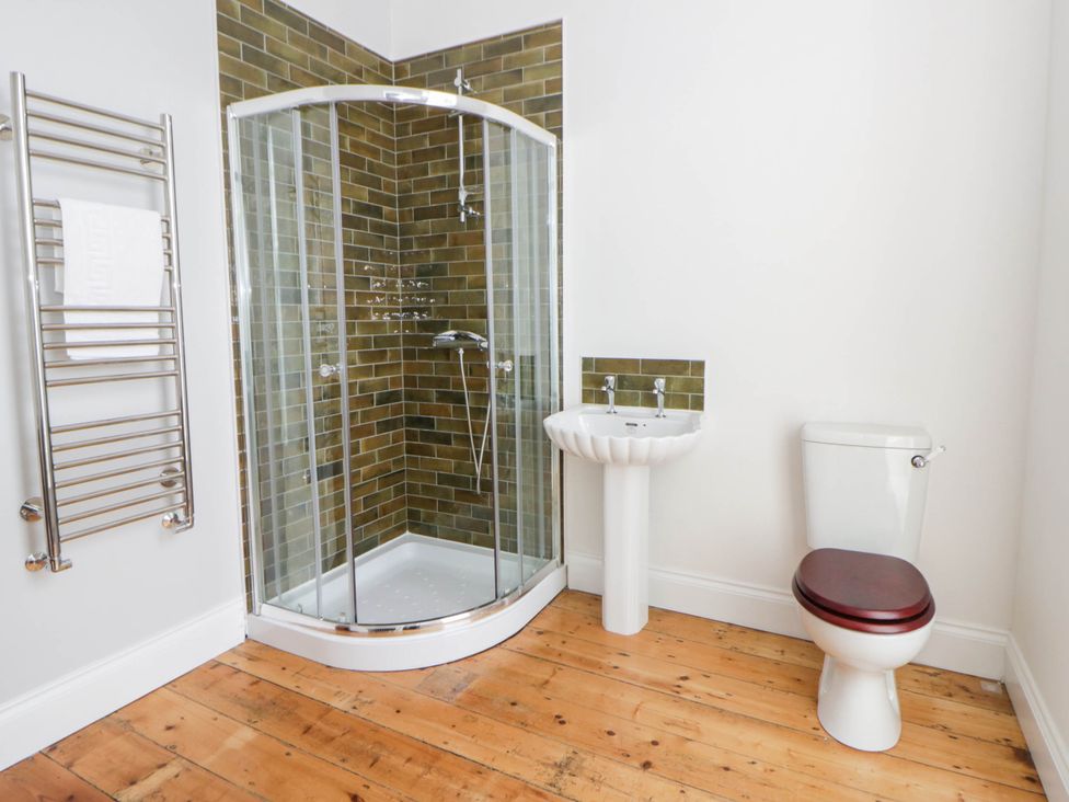 A bathroom with shower, toilet, and sink at Capel Llani in Llanidloes