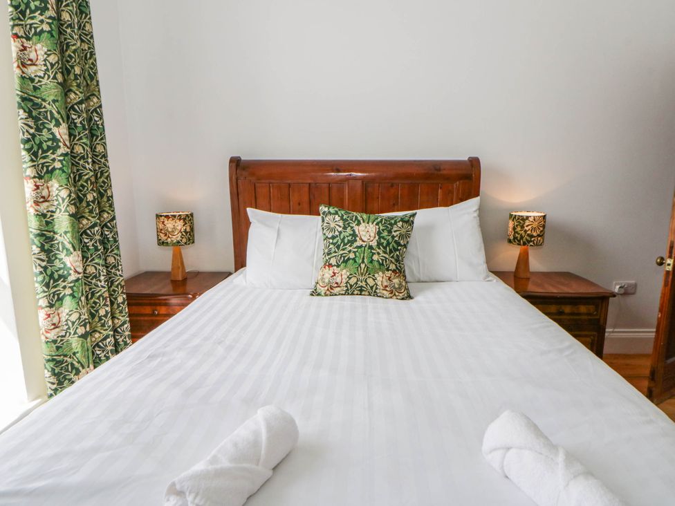 A bedroom with a bed and nightstands at Capel Llani Llanidloes