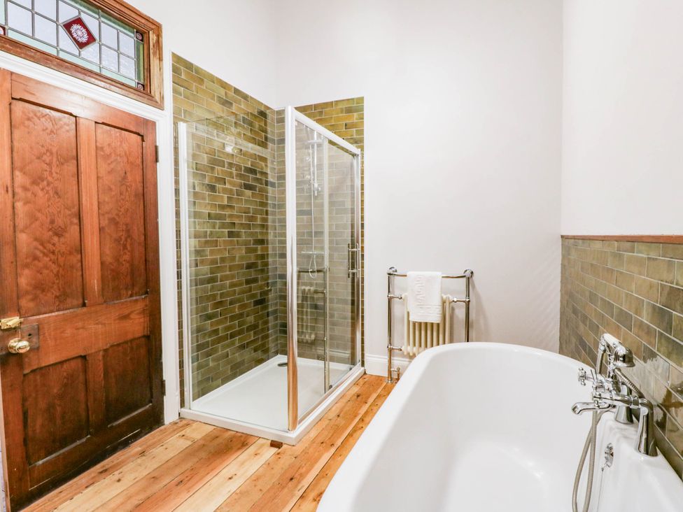 A bathroom with a shower and bathtub at Capel Llani in Llanidloes