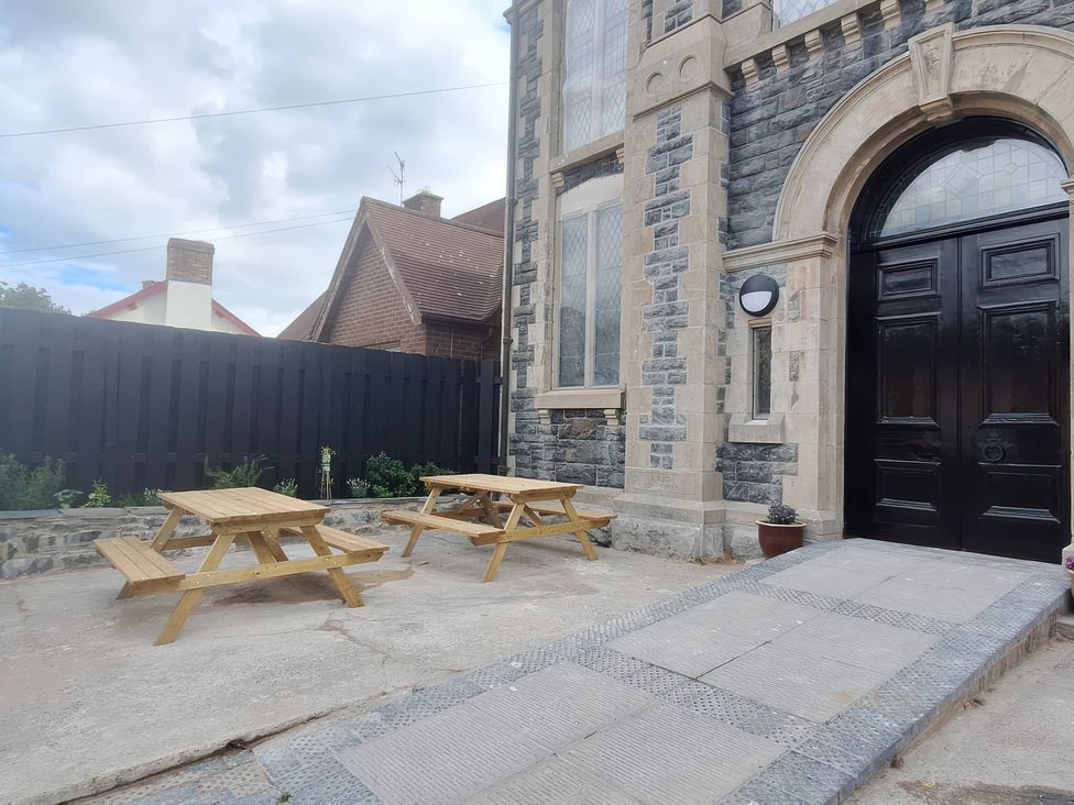 An outdoor area with tables and benches at Capel Llani Llanidloes