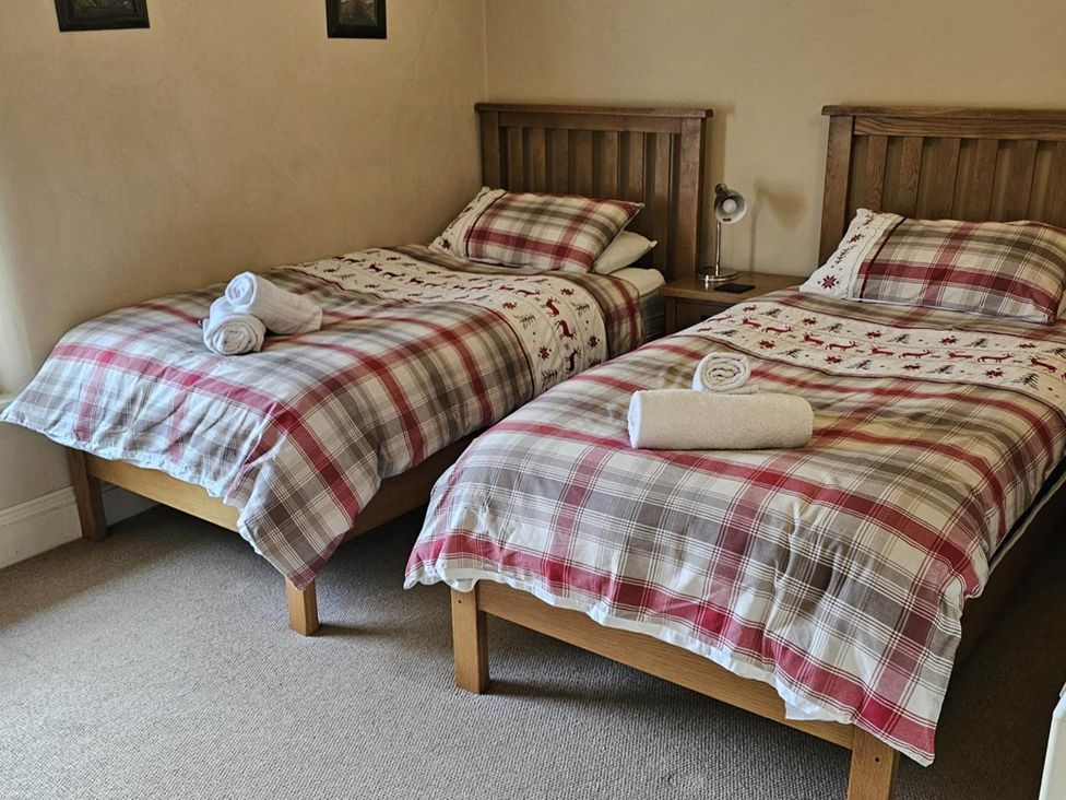A bedroom with two beds and a bedside lamp at the property