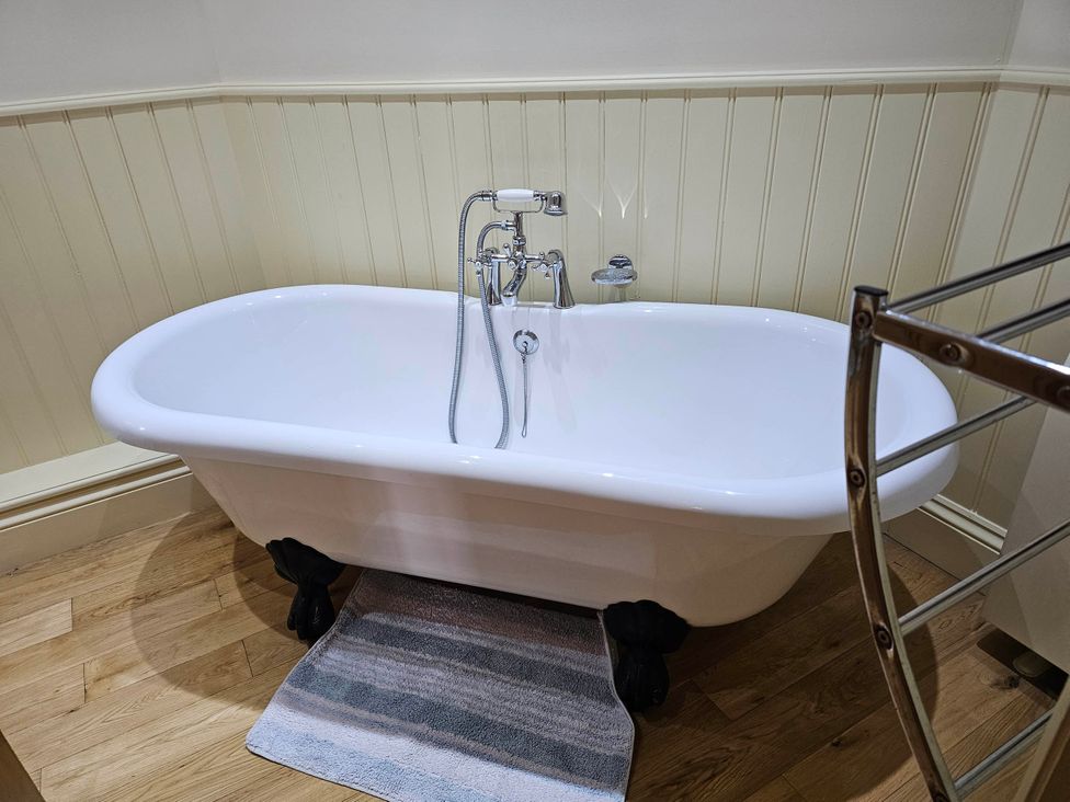 A bathroom with a bathtub and towel rail