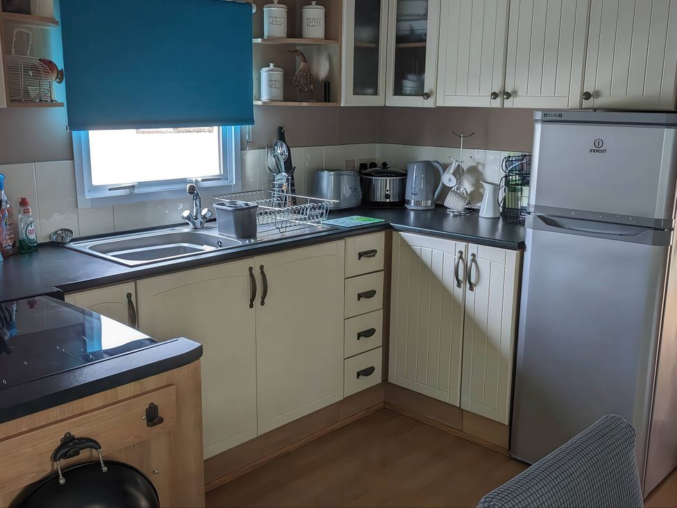 A kitchen with a sink, refrigerator, and kettle at the property
