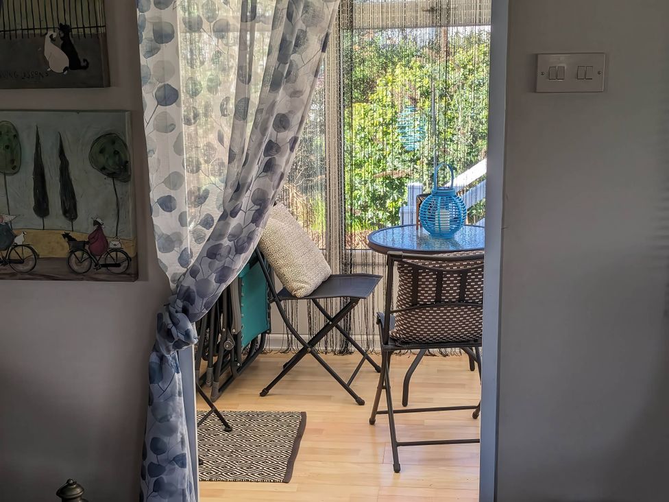 A sunroom with a table and chairs at the property in the garden
