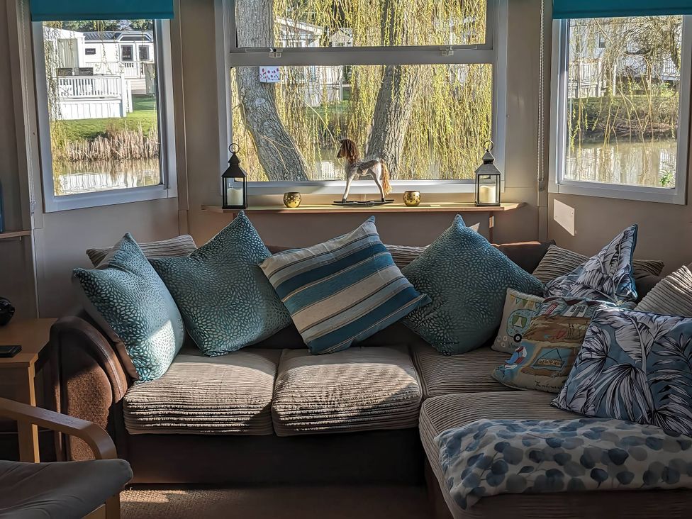 A living room with a couch and pillows near windows at the property located by the water