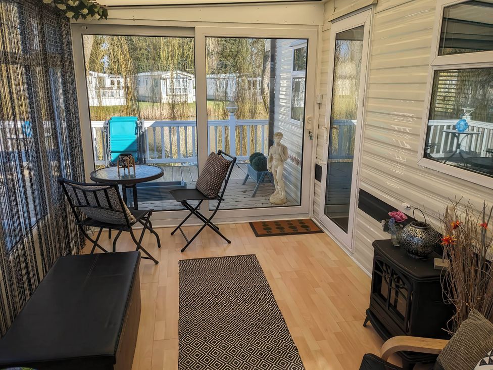A conservatory with chairs and a table at The Old Barn in Manchester