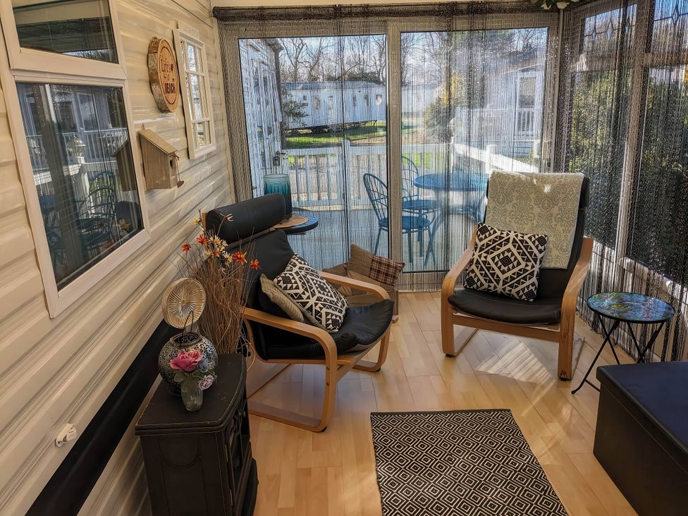 A sunroom with chairs and table at The Old Barn in Manchester