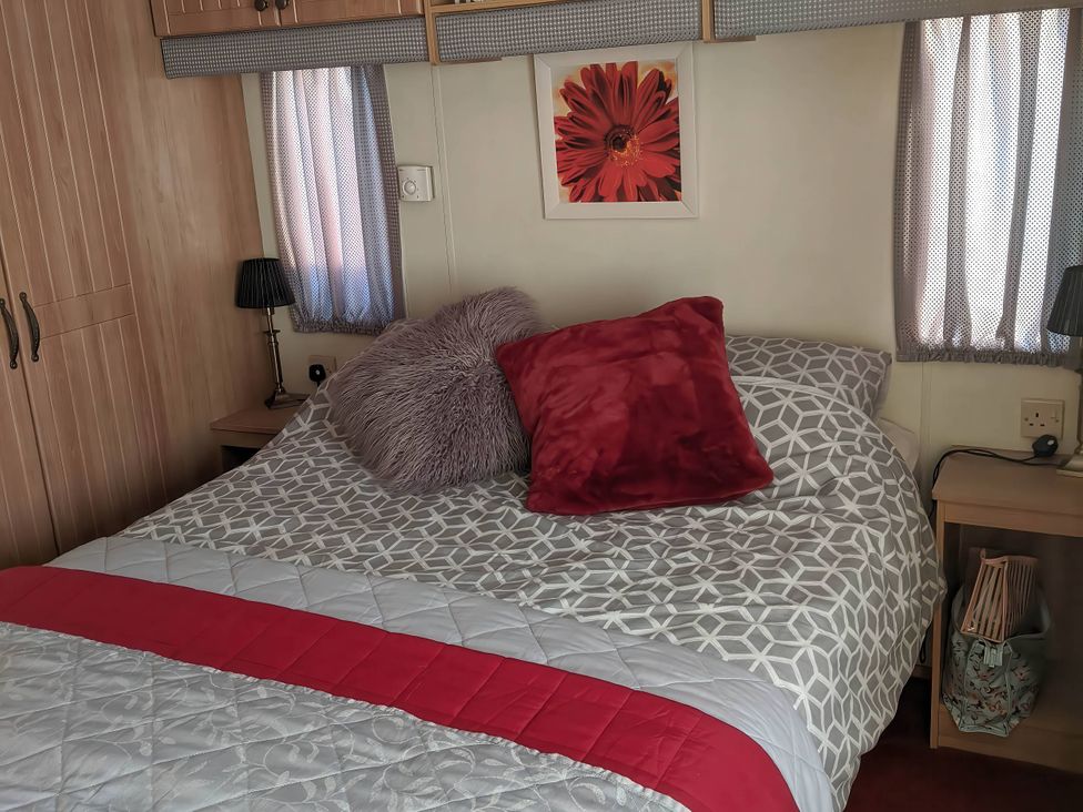 A bedroom with a bed and bedside lamps at 