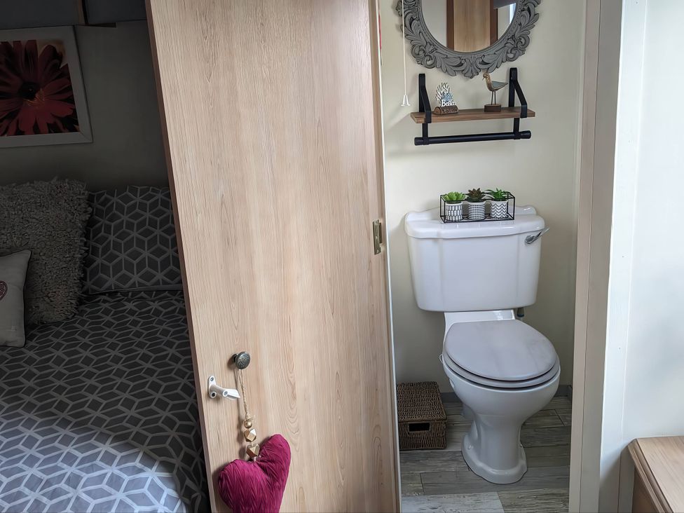 A bathroom with a toilet and a mirror at The Old Barn in Manchester