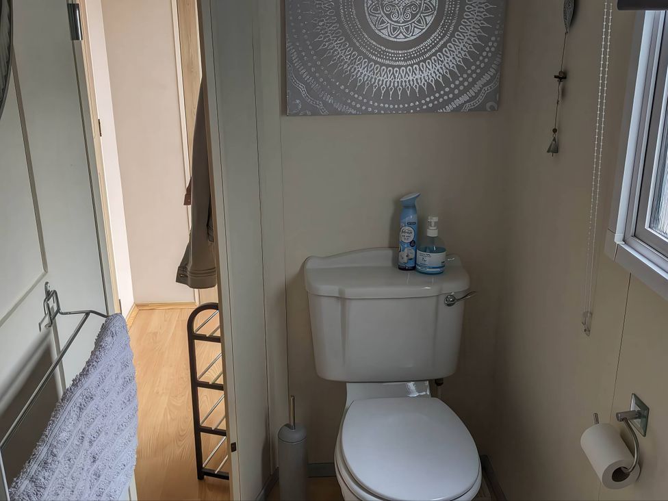 A bathroom with a toilet and cleaning supplies at the property in location