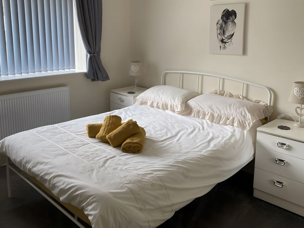 A bedroom with a bed and side tables at Ivy Corner